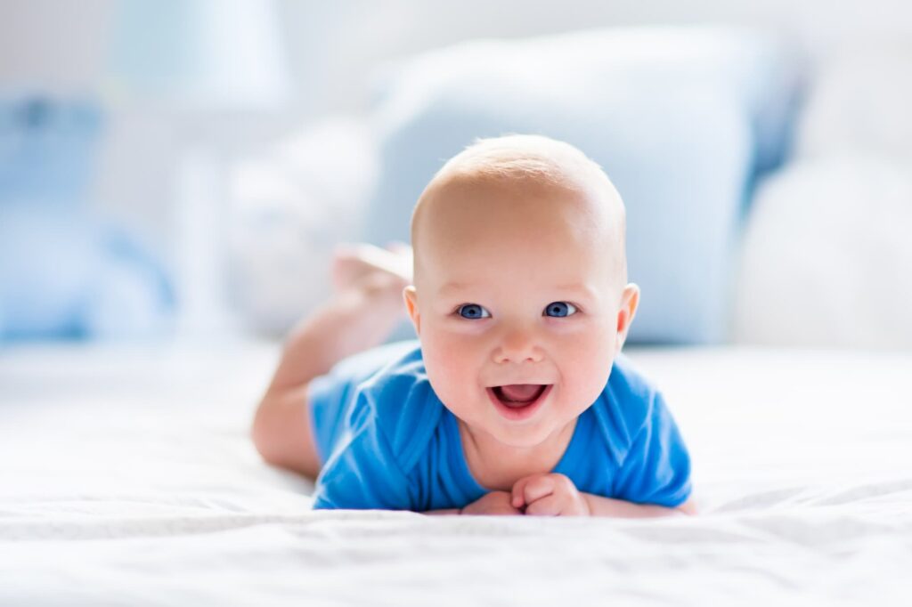 A smiling baby lying on their front