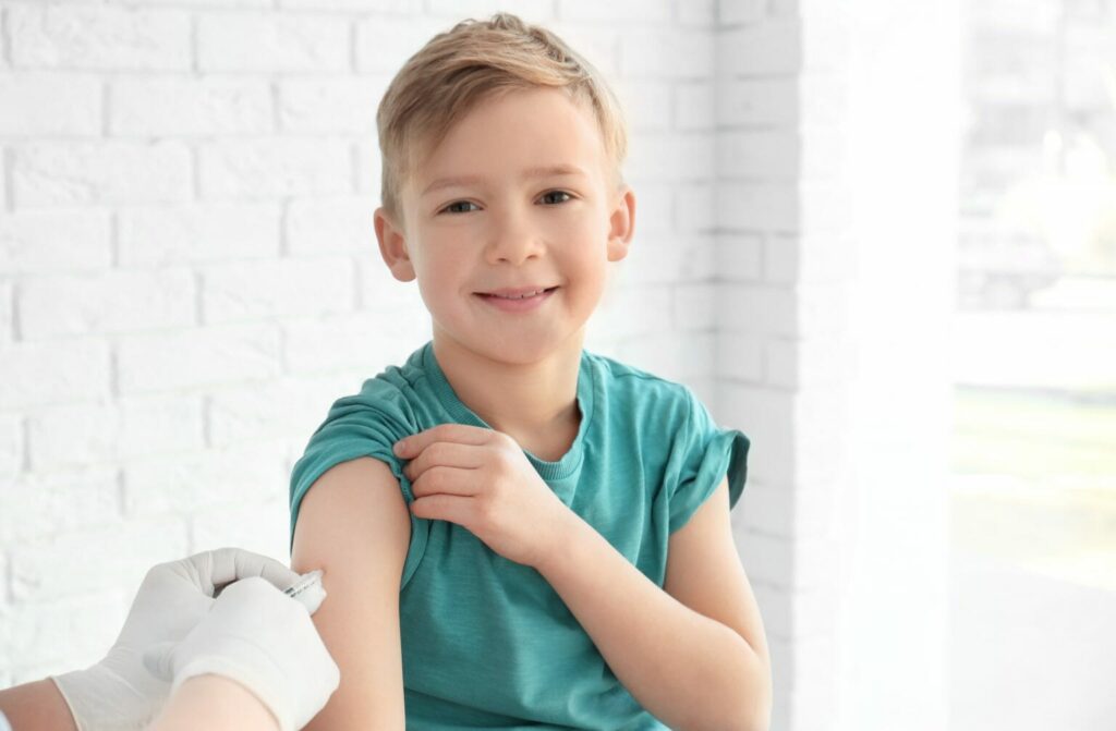 A boy smiling whilst being vaccinated